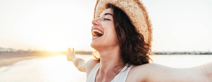Eine Frau lacht am Strand