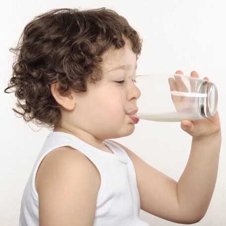 Kind trinkt Milch aus Glas