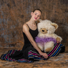 junge Tänzerin sitzend, mit Teddy im Tutu auf dem Schoß