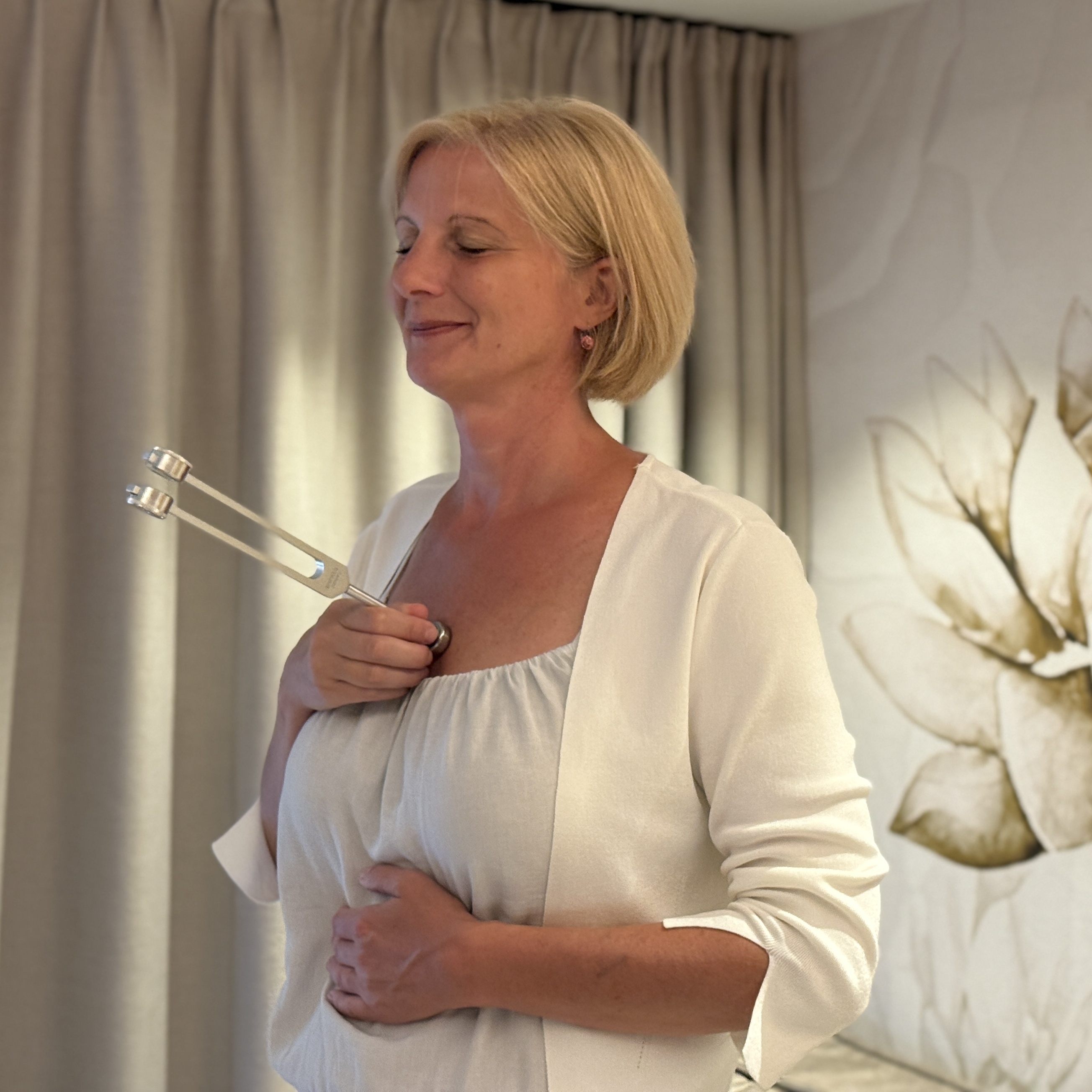 entspannte Frau mit Stimmgabel auf dem Brustbein