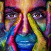 Frau mit Händen im Gesicht, Augen, Nase, mUnd liegen frei. Stärke ausdrückend, bunt mit Farbe bedeckt
