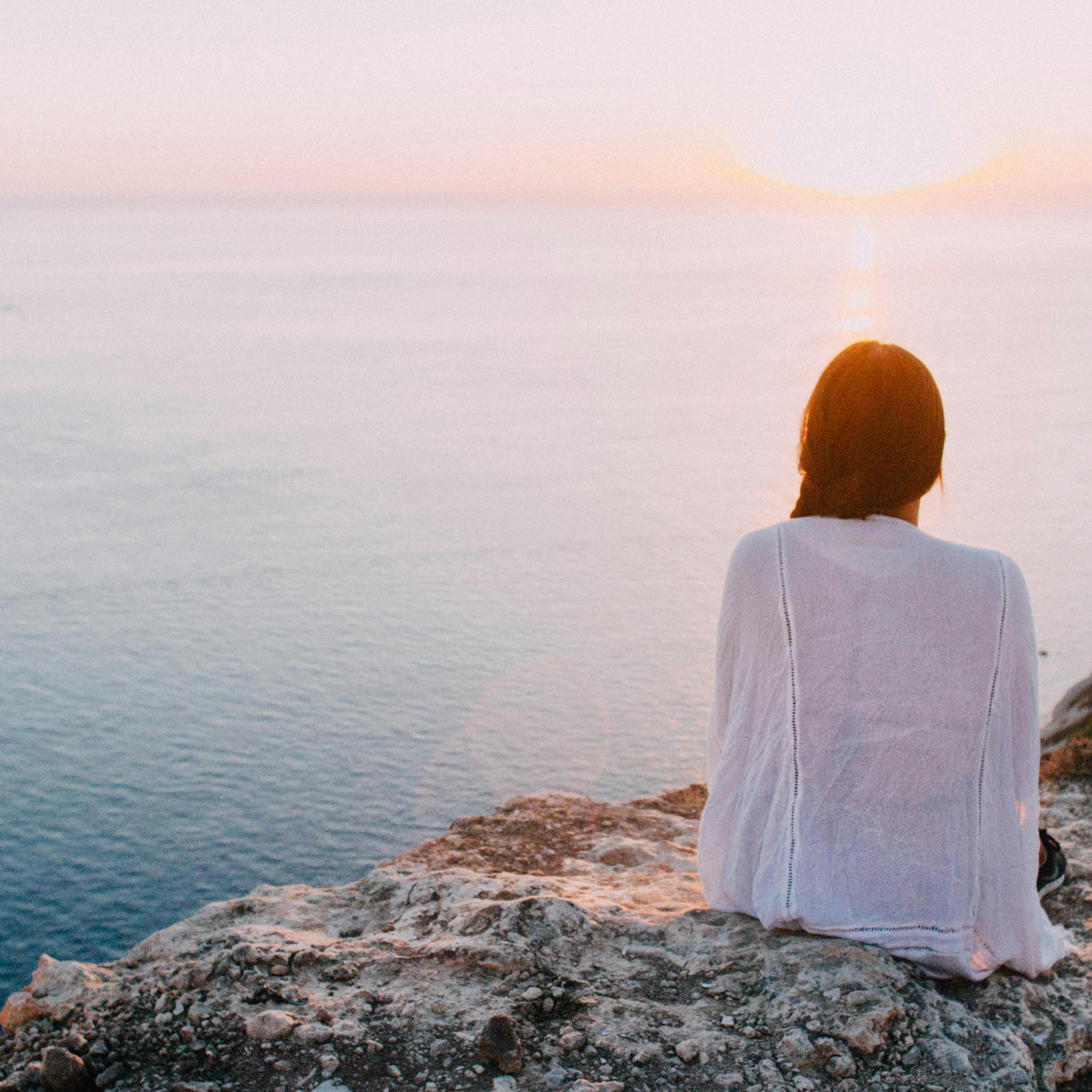 Foto von Riccardo: https://www.pexels.com/de-de/foto/frau-die-auf-grauem-felsen-nahe-korper-des-wassers-sitzt-185801/
