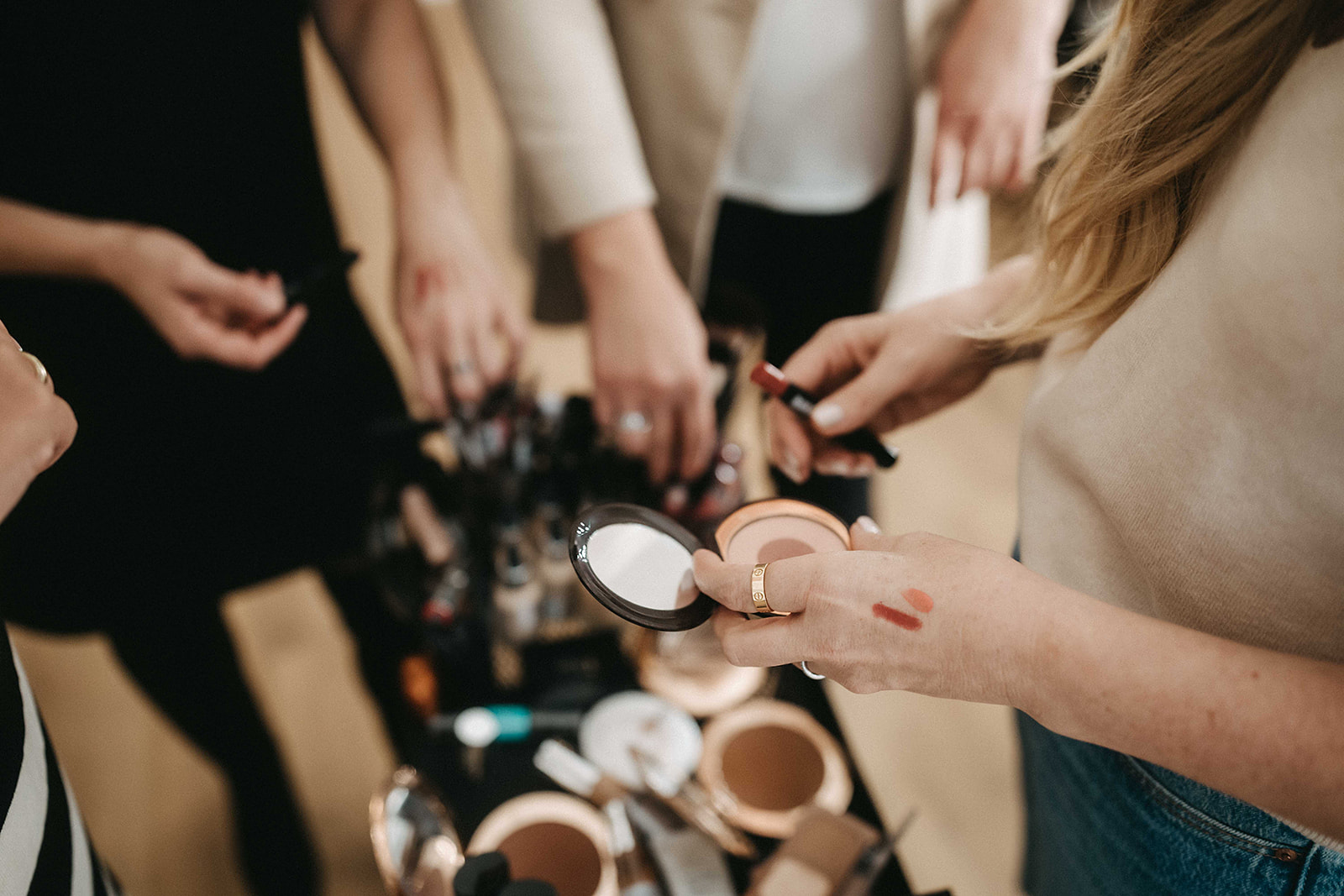 Gruppe von Frauen hält Make-up-Produkte – Workshop-Feeling